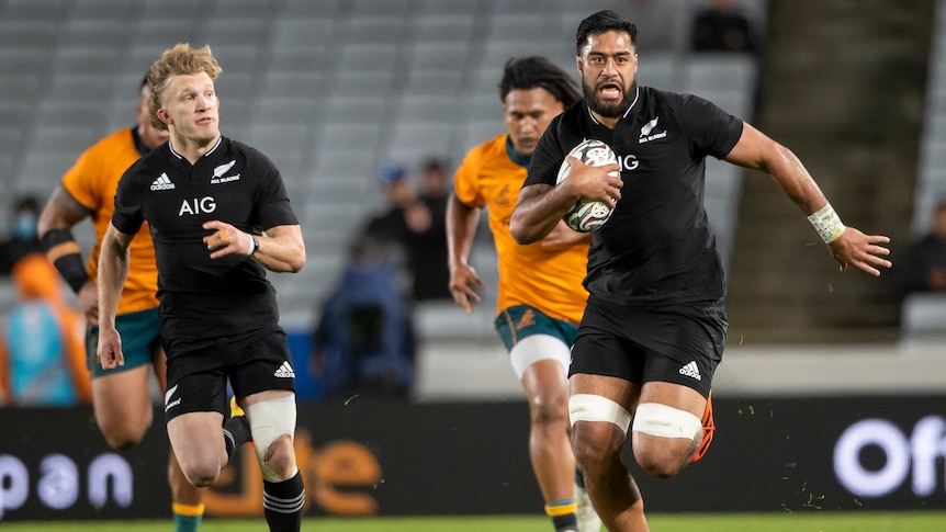 A New Zealand player runs free with a teammate on his shoulder as the Wallabies are left behind.