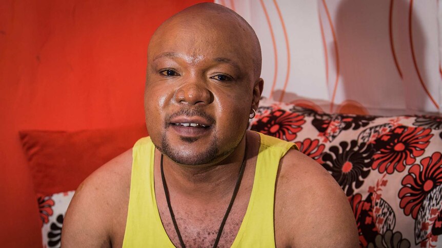 Mama G sits on his couch in his apartment in Nairobi
