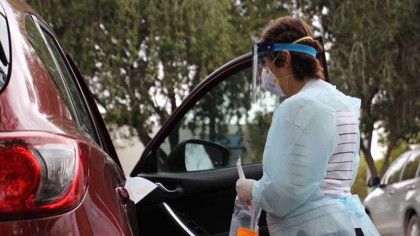 Leanne Adcock holding a bag and preparing to test a person for coronavirus.