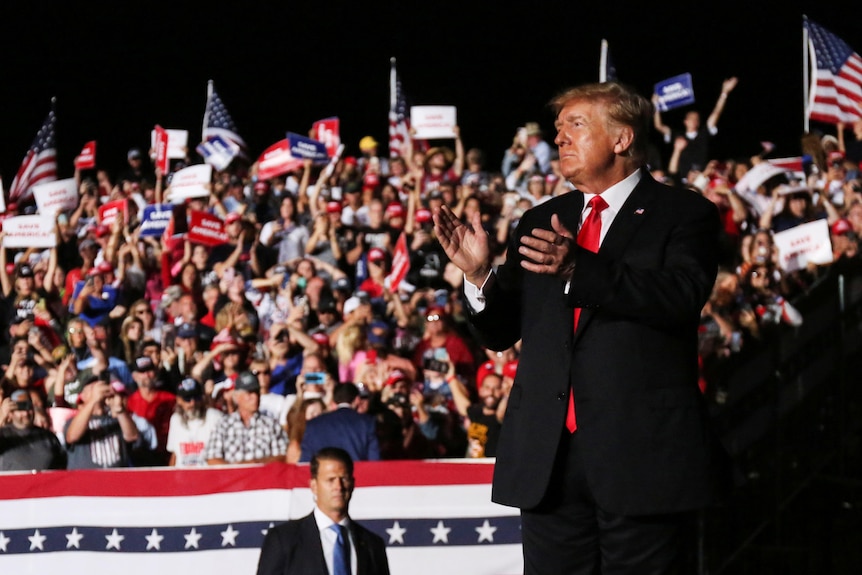 Former U.S. President Donald Trump applauds after his speech during a rally