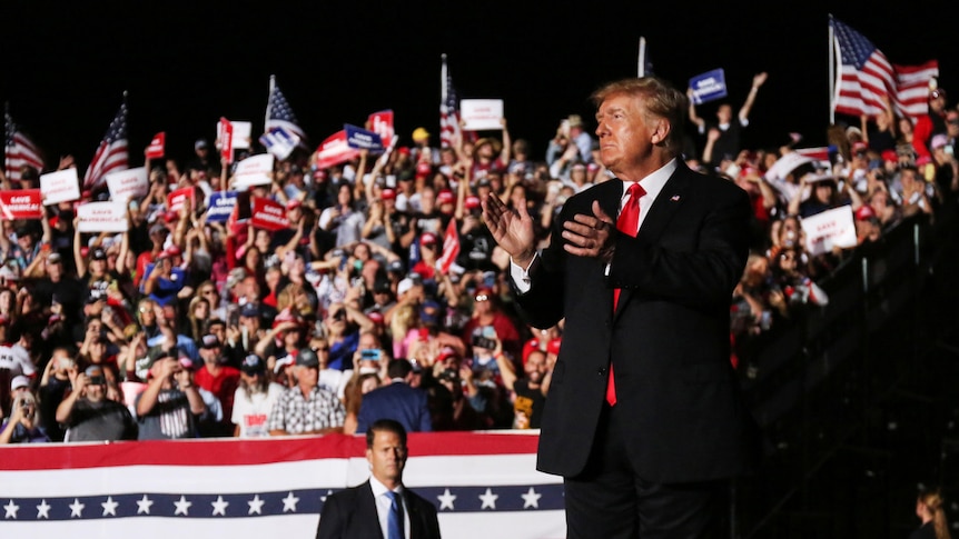 Former U.S. President Donald Trump applauds after his speech during a rally