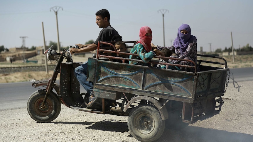 Syrian Kurdish civilians board vehicle as they flee reported shelling in the northeastern governorate of Hasakah, August 2016.