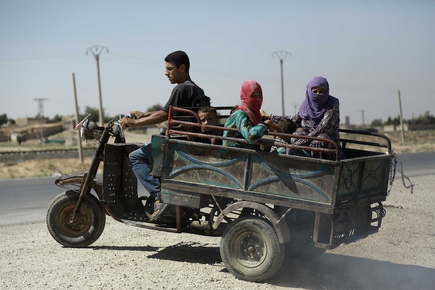 Syrian Kurdish civilians board vehicle as they flee reported shelling in the northeastern governorate of Hasakah, August 2016.