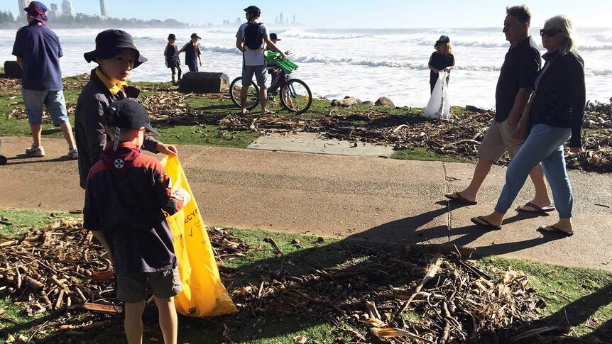 Kids help to clean up king tide detritus along the Burleigh beachfront
