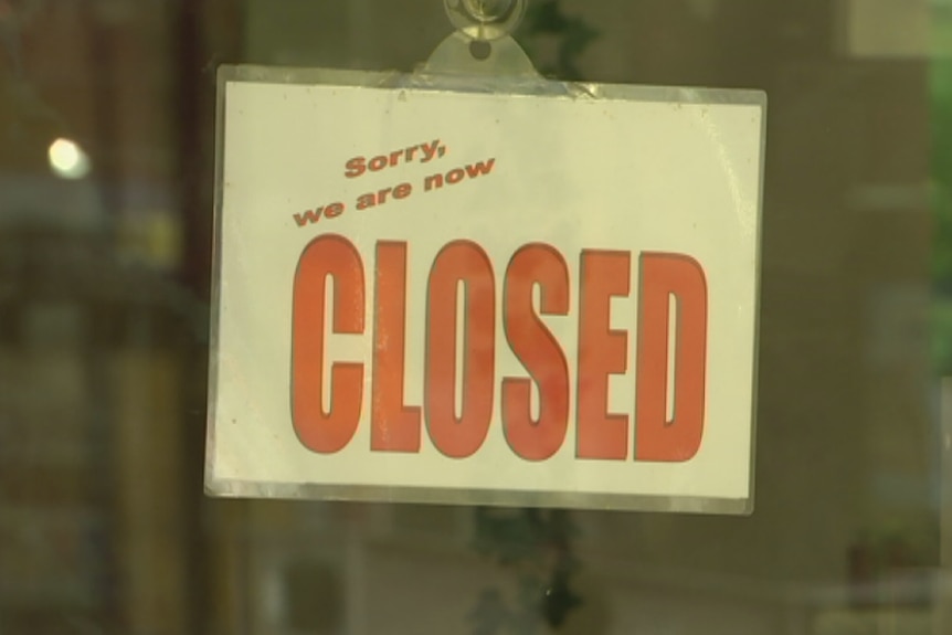 Closed sign hanging in the window of a business.