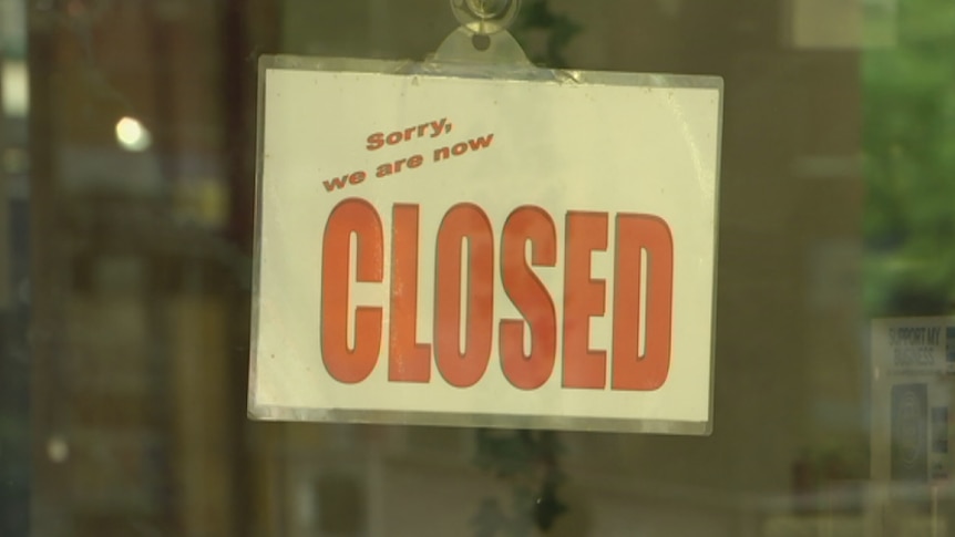 Closed sign hanging in the window of a business.
