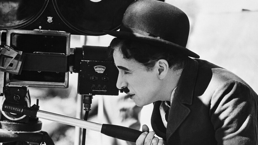 Actor Charlie Chaplin looks though a movie camera on April 22, 1935