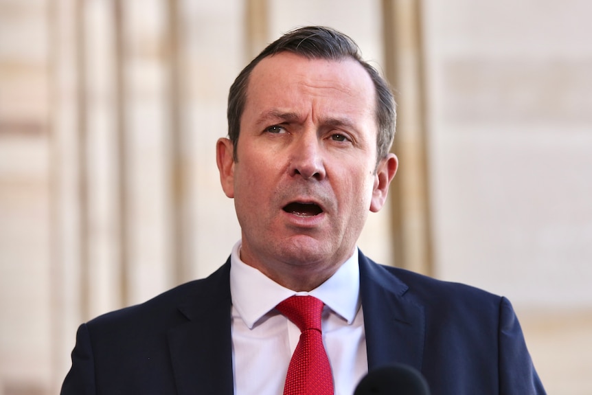 WA Premier Mark McGowan, speaking at a press conference outside parliament, mouth open, mid speaking
