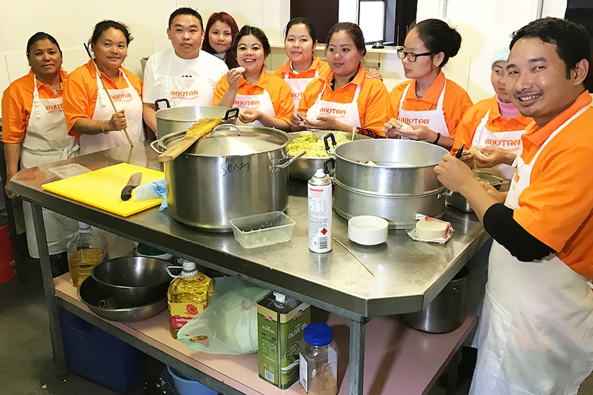 Bhutanese people gathered in a kitchen.