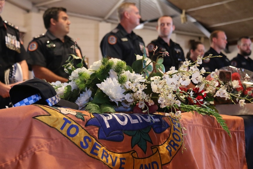 Police stand over the coffin of Mr E Perdjert