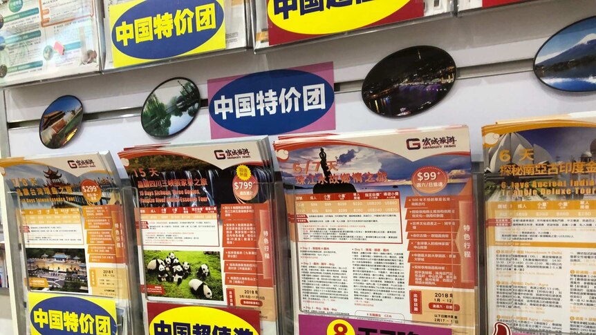 Travel deals to China on pamphlets, written in Chinese characters