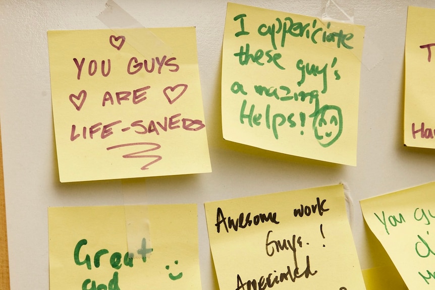 Yellow post-it notes of appreciation are taped to a white board.