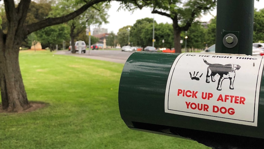 A sign at a park that says pick up after your dog