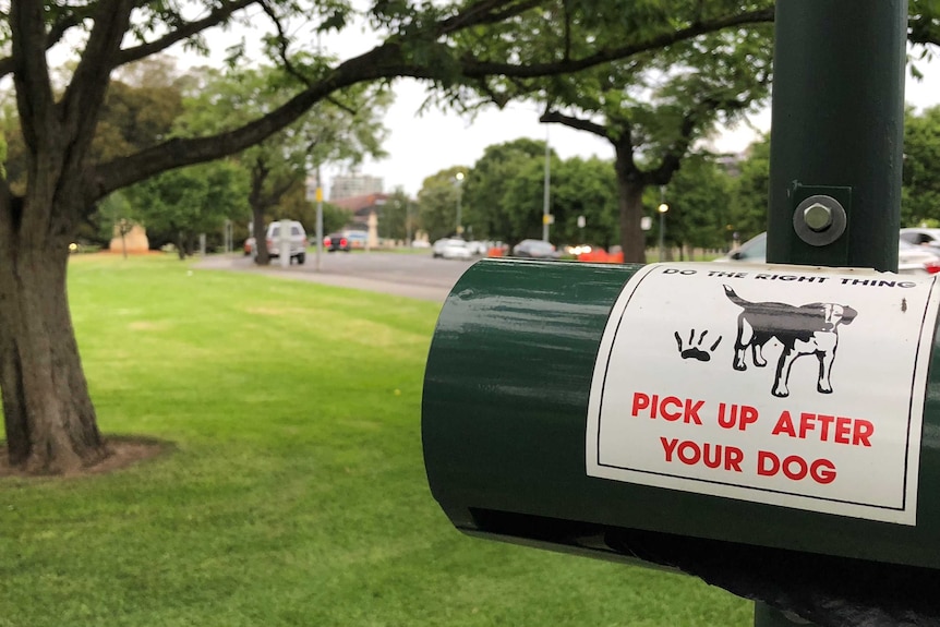 A sign at a park that says pick up after your dog