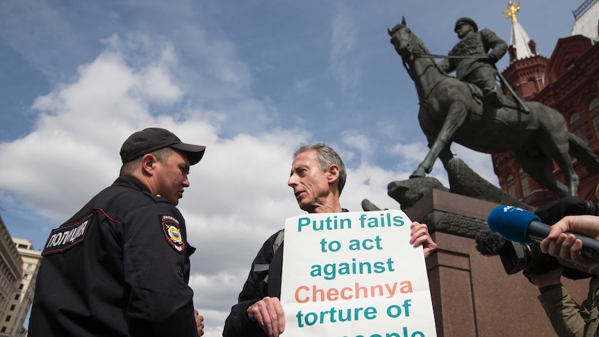 Tatchel, holding his protest sign "Putin fails to act against Chechnya torture of gay people"