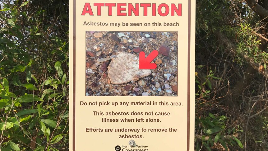 A sign with a photo of asbestos warning residents not to touch it at a beach.