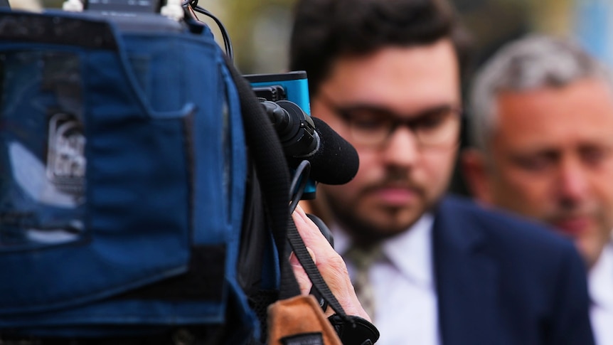 A man surrounded by cameras. 