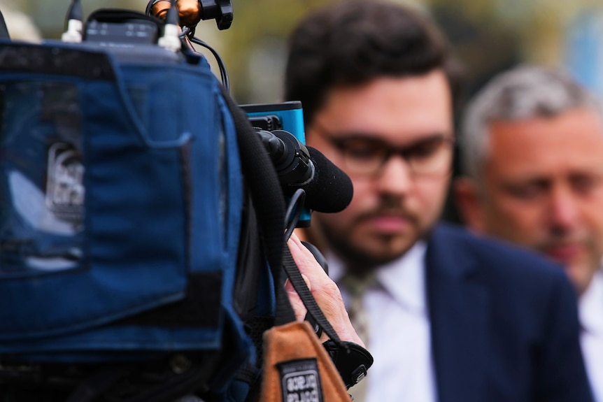 A man surrounded by cameras. 