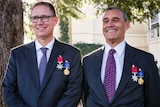 Richard Harris and Craig Challen, standing outside wearing their medals, smile.