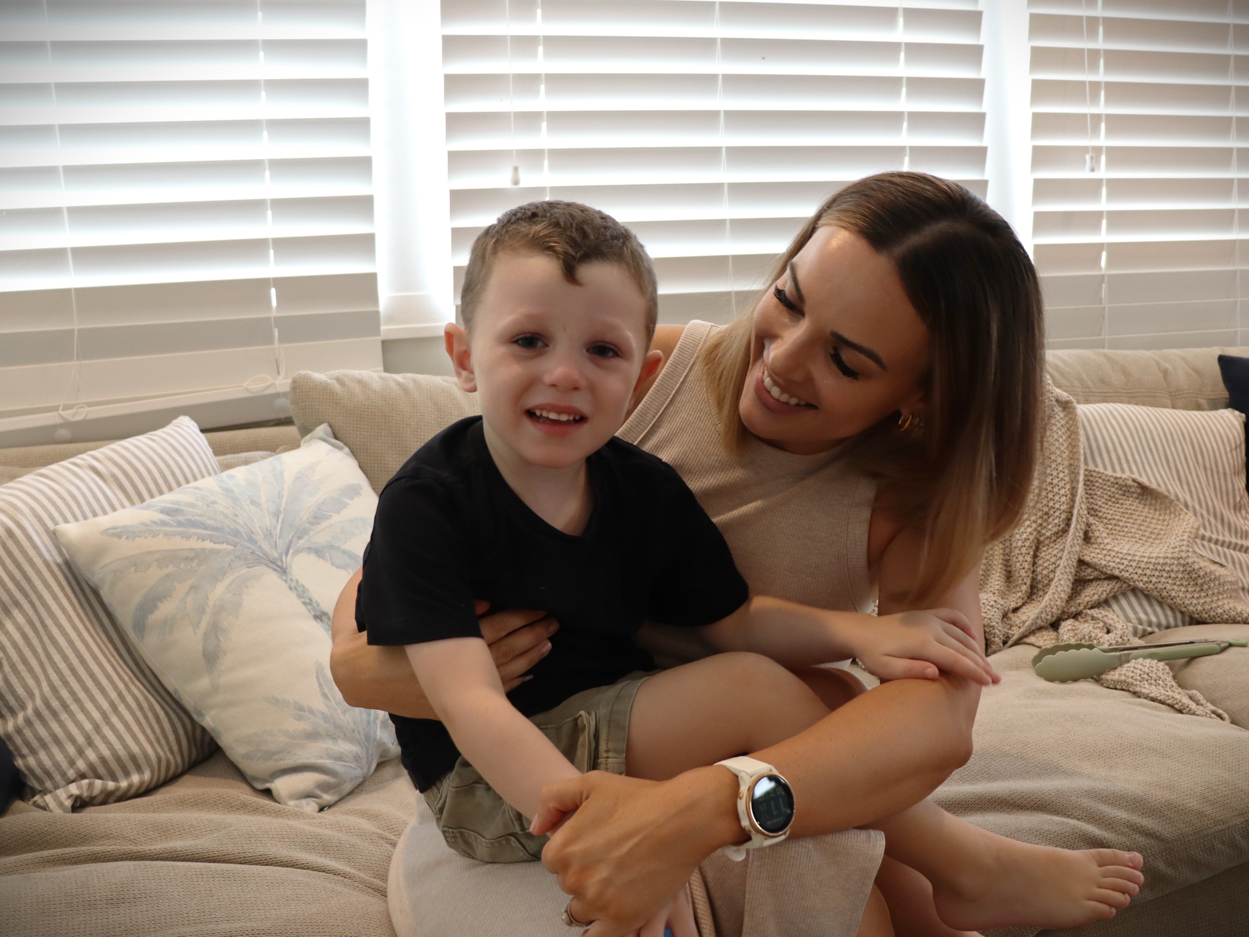 Woman holds child son and looks at him lovingly