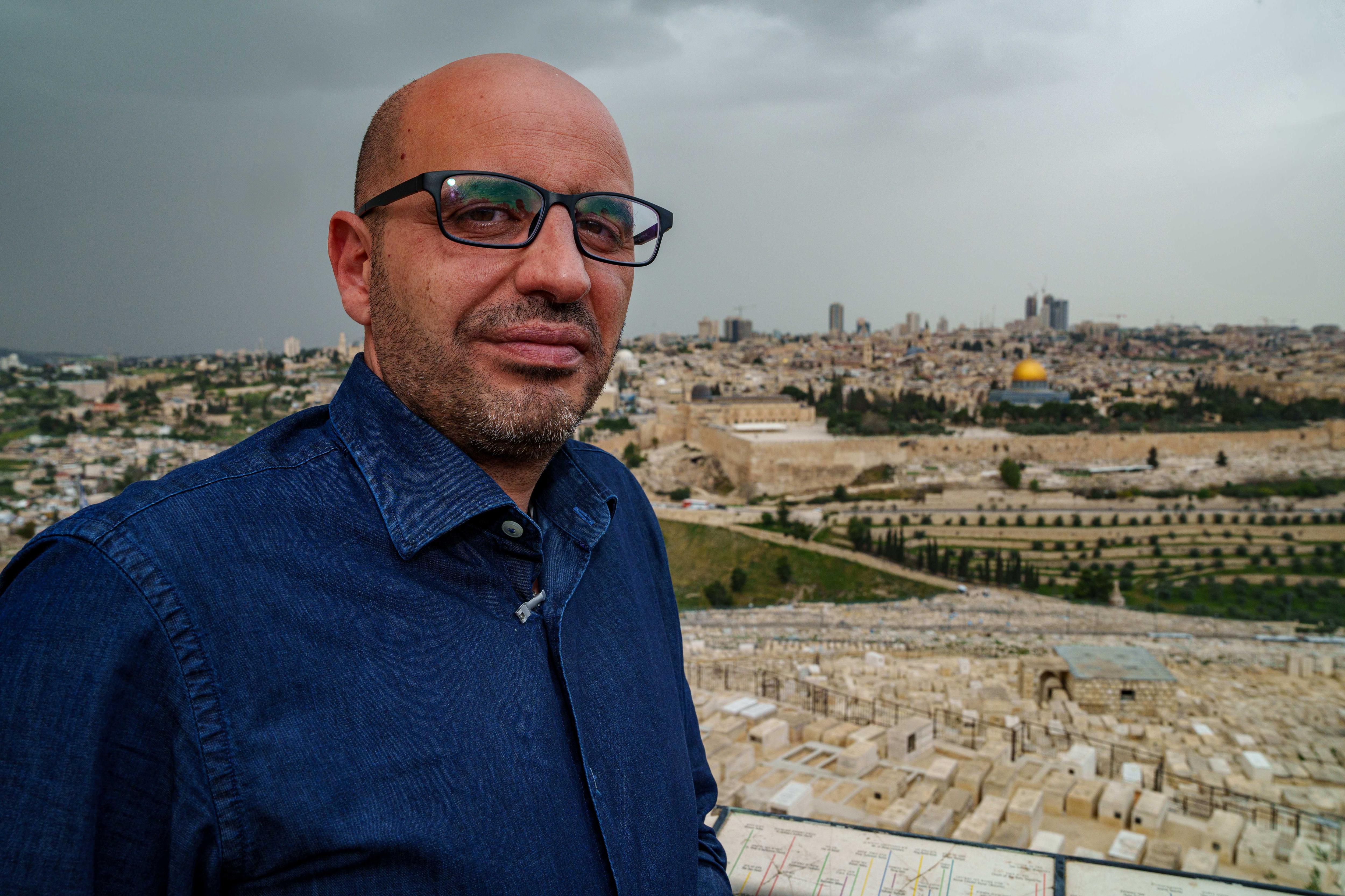 Muhammad Al-Ashab stands with the Dome of the Rock and the sprawl of Jerusalem behind.