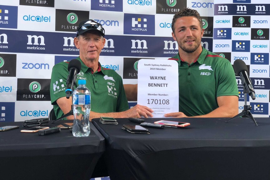 Wayne Bennett and Sam Burgess hold up Bennett's South Sydney membership certificate at a Rabbitohs media conference.