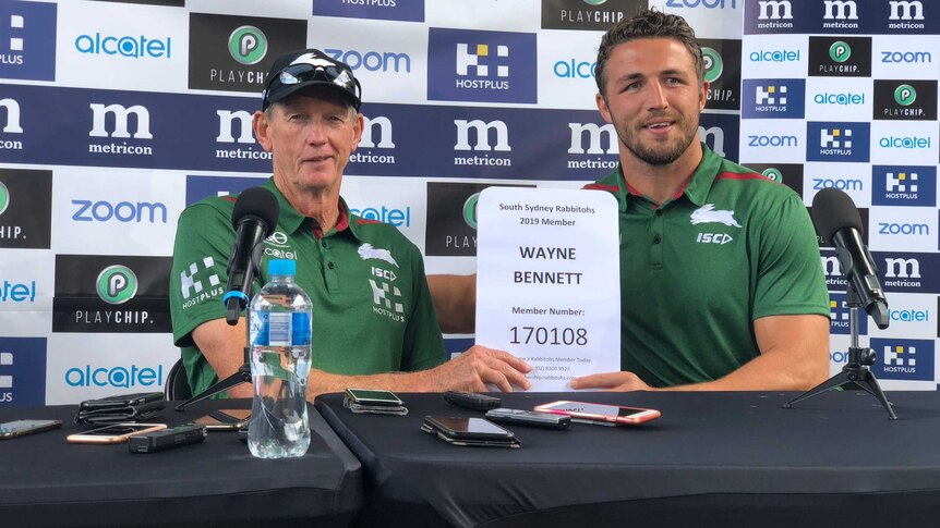 Wayne Bennett and Sam Burgess hold up Bennett's South Sydney membership certificate at a Rabbitohs media conference.