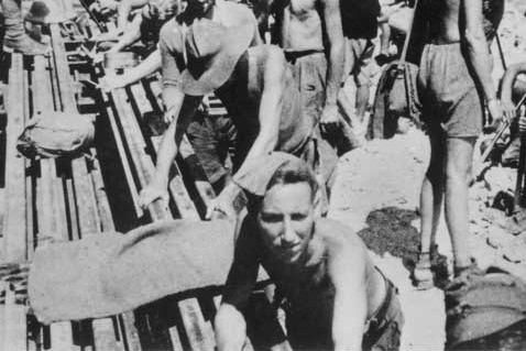 A black and white photo of prisoners of war working on the Thai-Burma Railway.