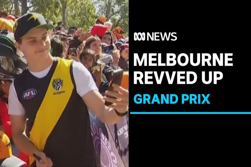 Melbourne Revved Up, Grand Prix: A man wearing an AFL guernsey takes a selfie with fans.