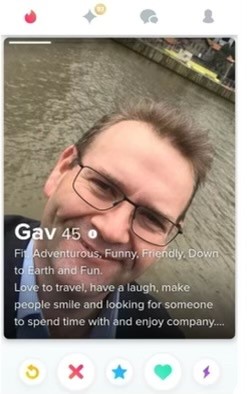 A screenshot of a Tinder profile of a man wearing glasses.
