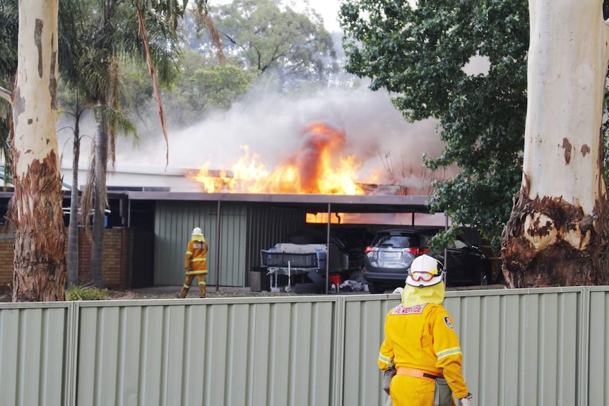 Firefighters near a burning house.