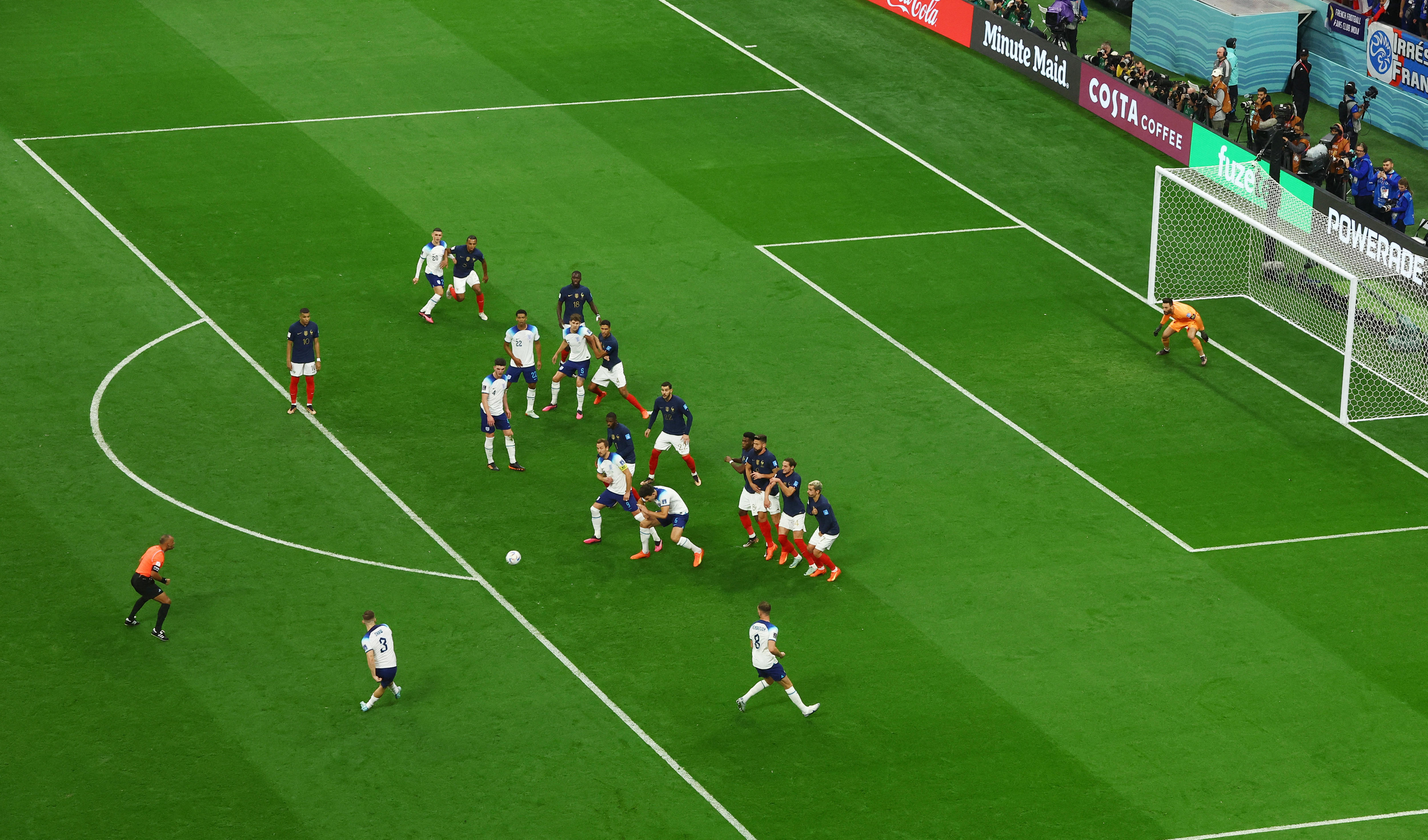 England's Luke Shaw shoots a goal from a free kick, past a wall of defenders.