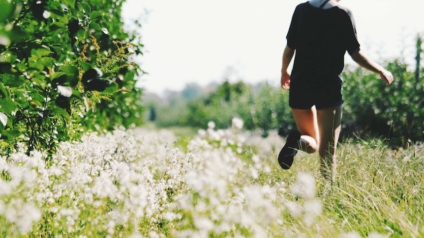 An unidentified person running in a meadow