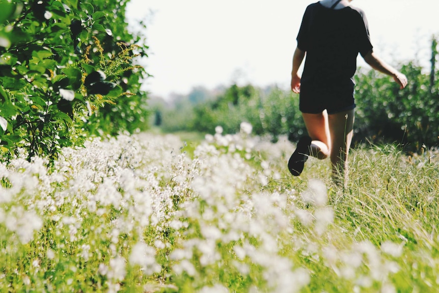 An unidentified person running in a meadow