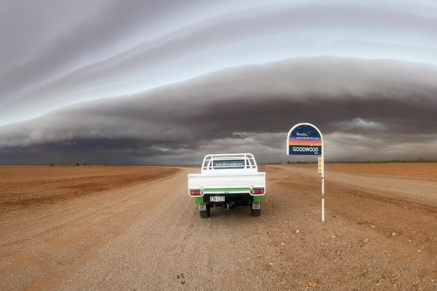ute parked in front of massive scary looking storm cloud