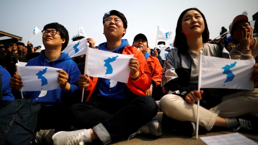 People hold the Korean unification flag.