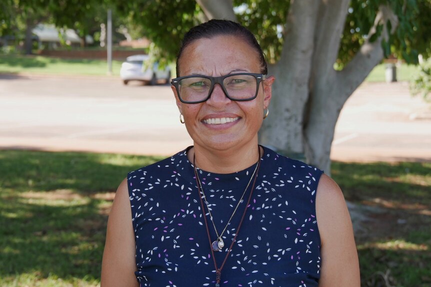 Aboriginal Family Legal Services Community Engagement Worker Mary Lane standing beneath a tree. 