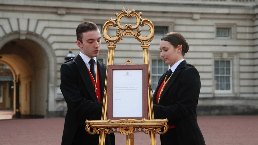 Footmen bring out the easel in the forecourt of Buckingham Palace to formally announce the birth of a baby boy.
