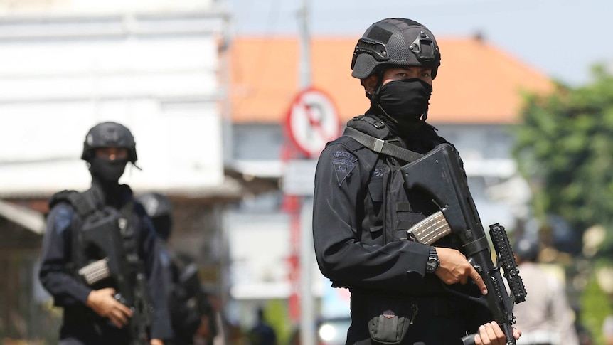 Police stand guard after explosion in Surabaya.