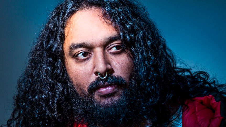 Ramesh Mario Nithiyendran pictured in front of a blue background.