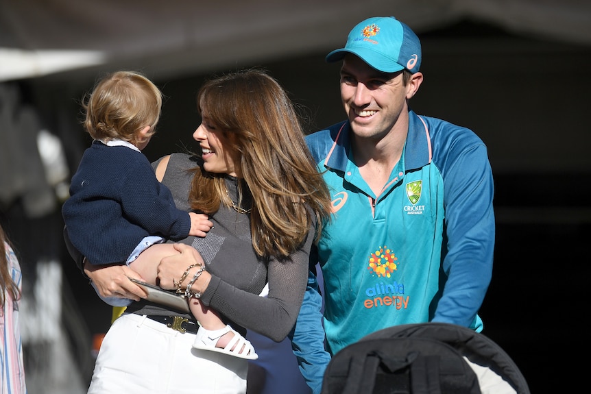 Pat Cummins wheels a pram as his wife holds their son