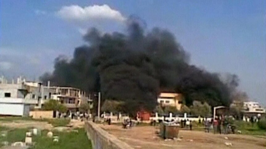 Flashpoint: smoke rises from a burning building in Deraa on Friday.