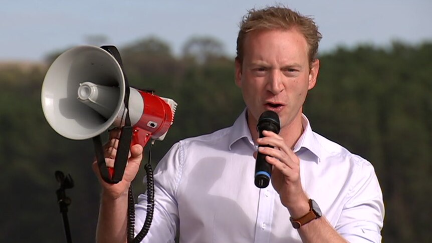 A man holding a bullhorn and a microphone