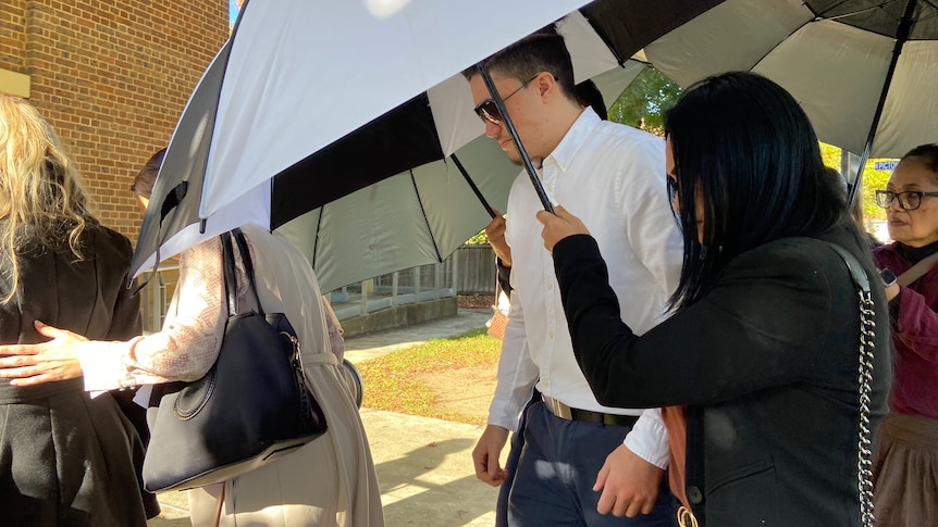 A group of people holding umbrellas