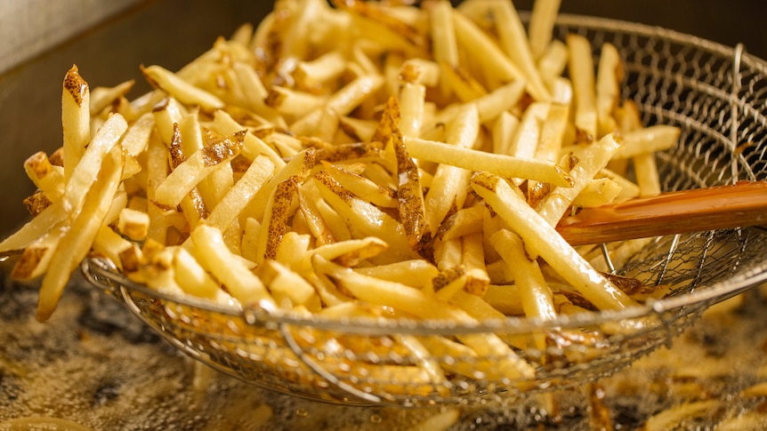 Stack of hot chips in a fryer basket