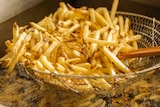 Stack of hot chips in a fryer basket