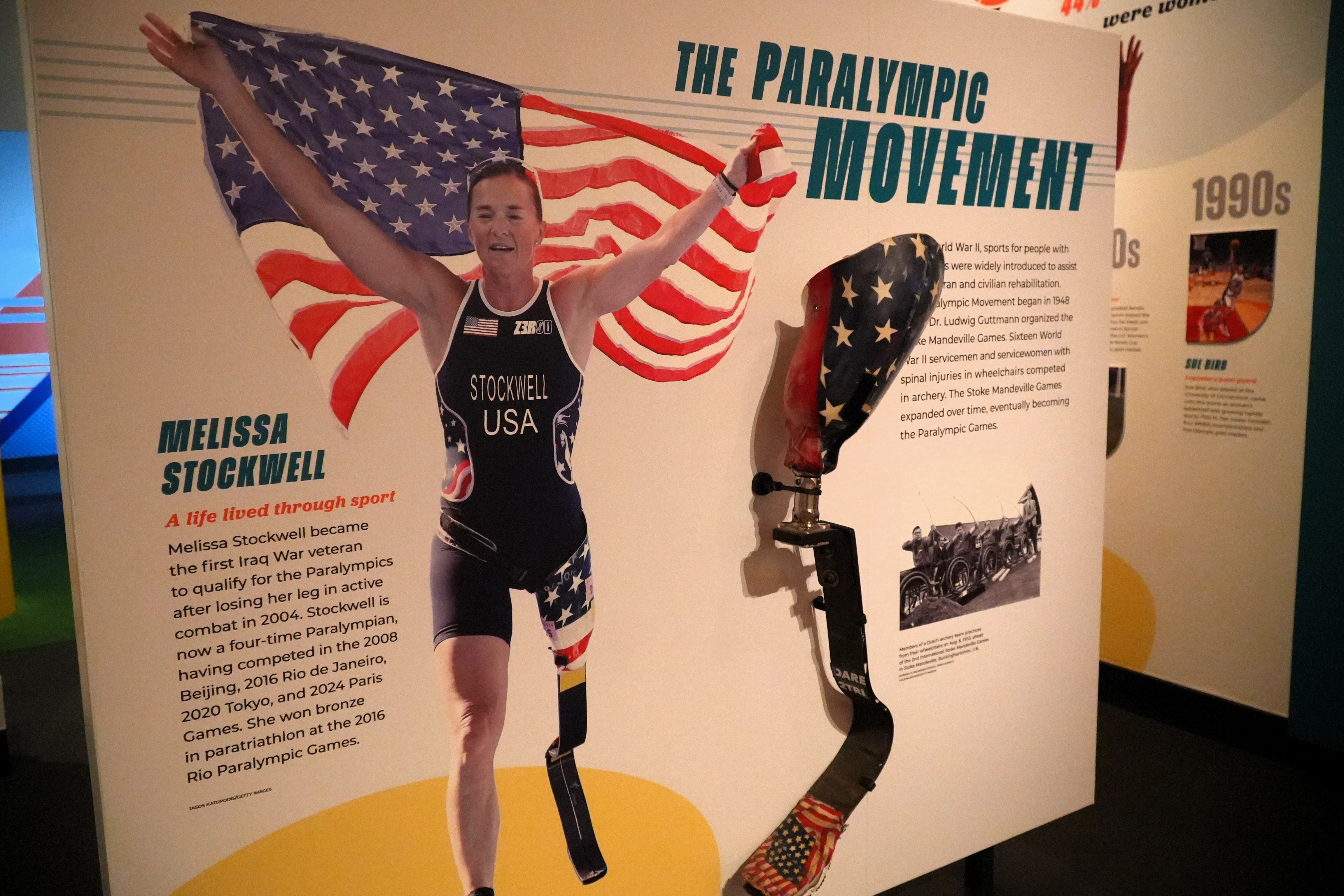 A picture of a female American Paralympian with a prosthetic leg holding an American flag