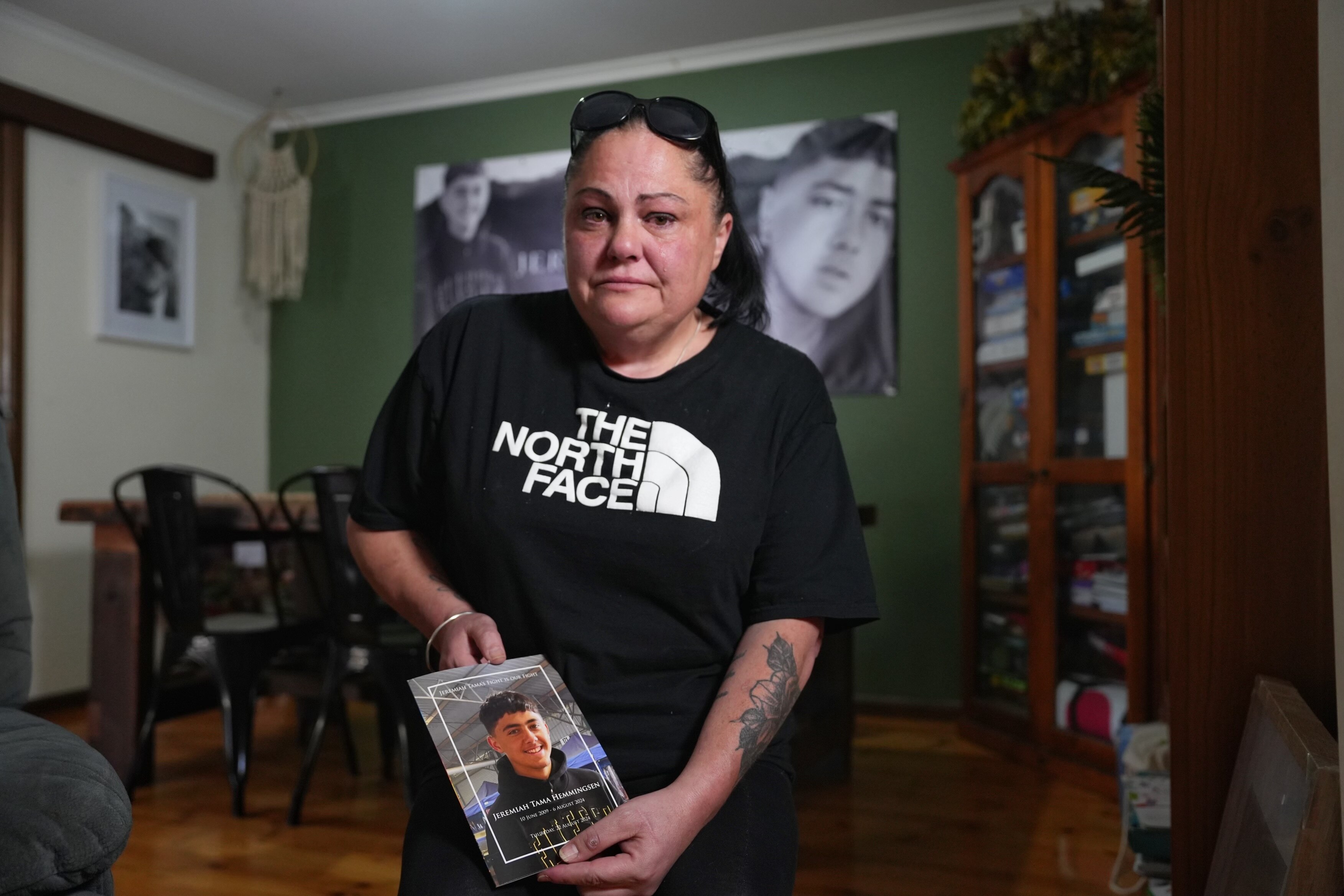 a woman with sunglasses on her head holds a funeral booklet