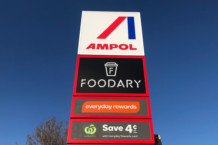 A petrol station sign saying AMPOL and FOODARY with a blue sky behind