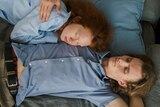 Man and woman hug in bed in a story about how attachment styles can affect your sex life and relationship.